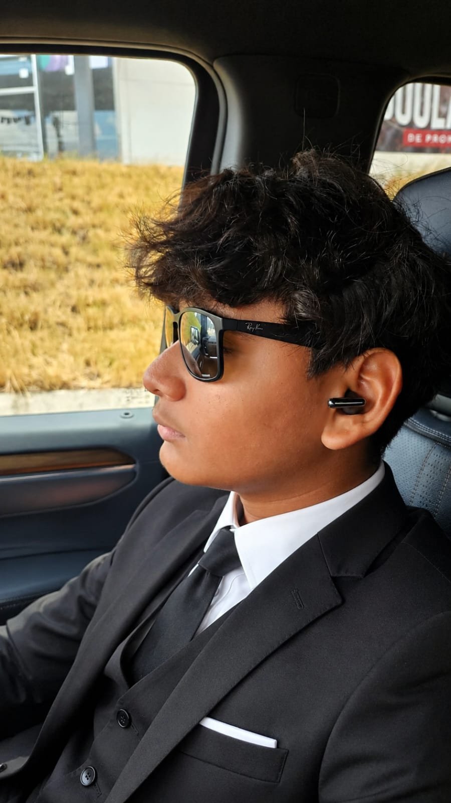 Aiser Antonio con traje de gala dentro del auto